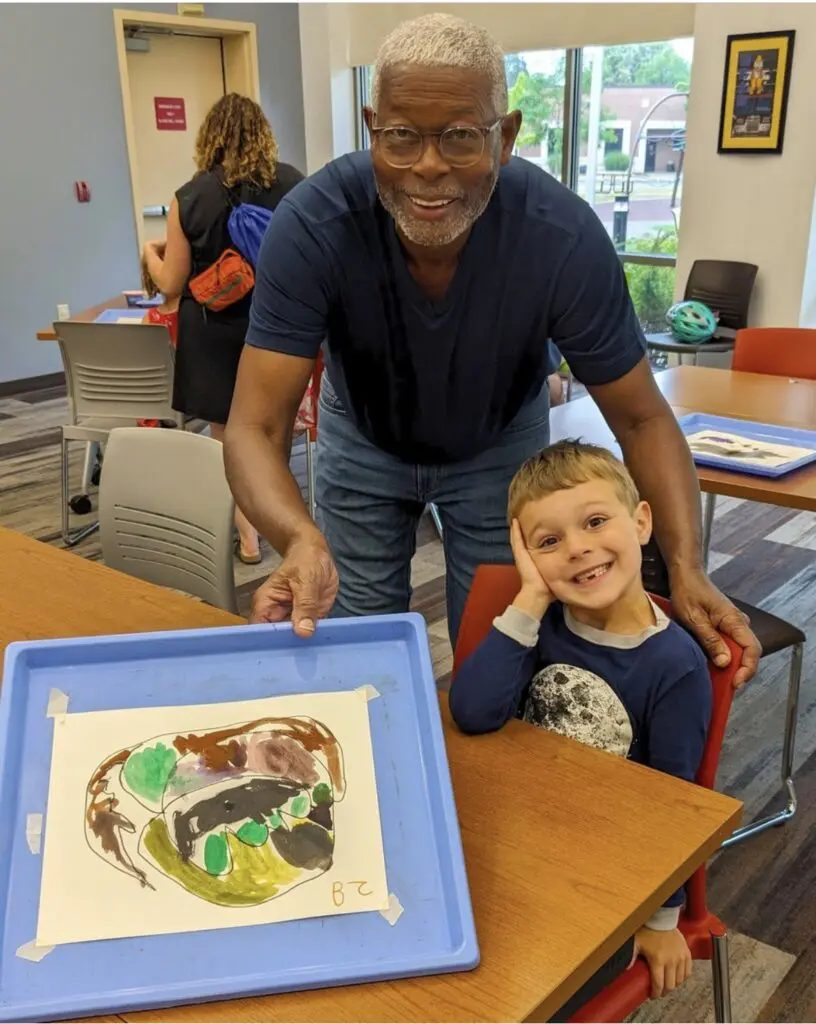 Floyd Newsum Jr. with a young student and her painting